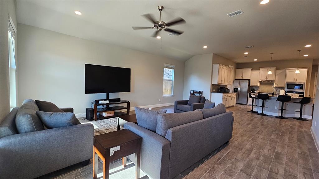 1405 Razorbill Road Denton, TX 76205 - Photo 16 of 40 a living room with furniture and a flat screen tv