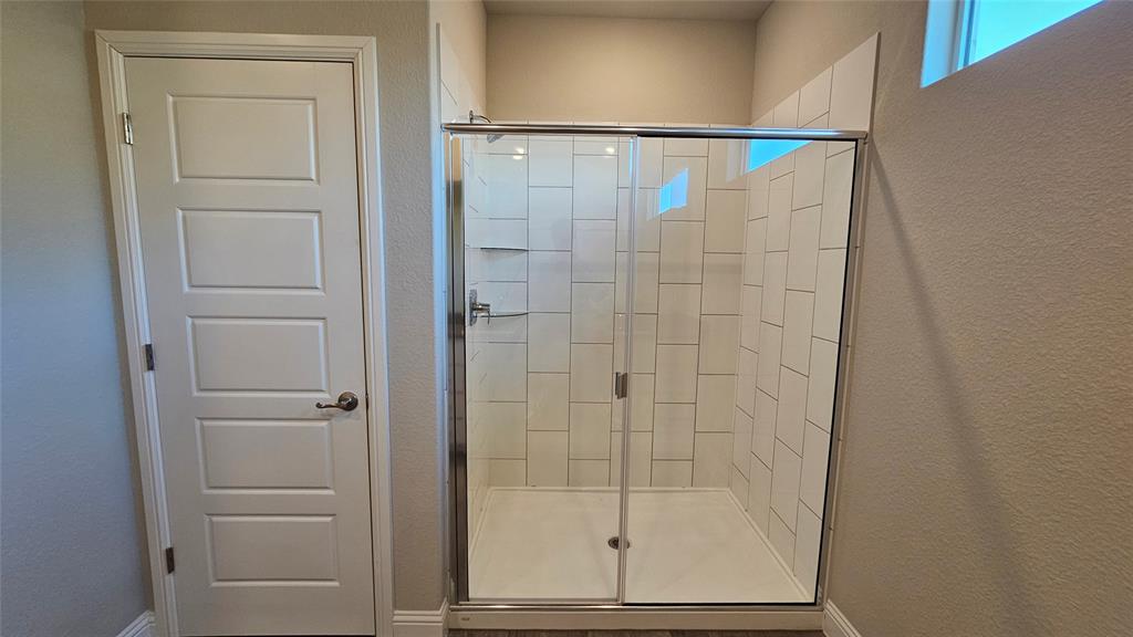 1405 Razorbill Road Denton, TX 76205 - Photo 22 of 40 a bathroom with a glass shower door