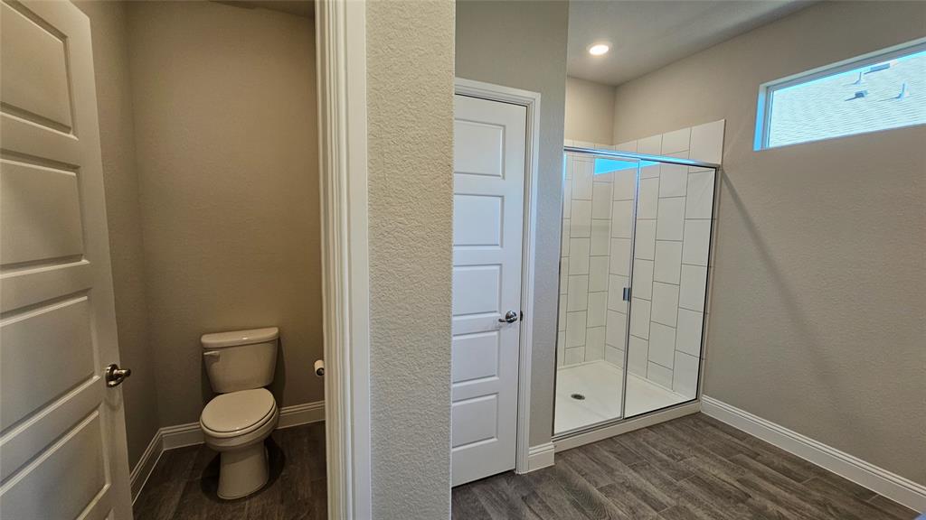 1405 Razorbill Road Denton, TX 76205 - Photo 26 of 40 a bathroom with a granite countertop toilet a sink and a mirror