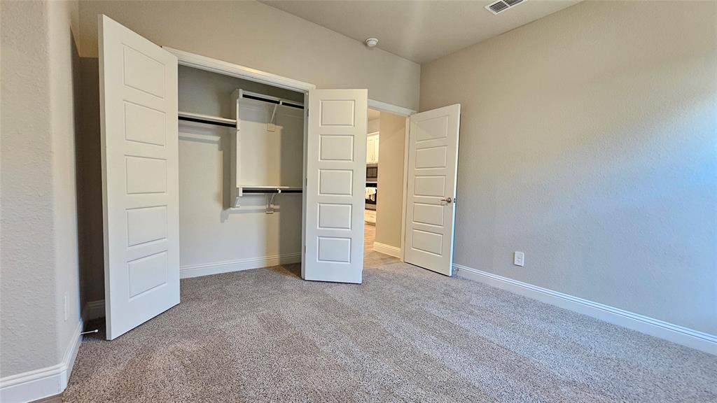 1405 Razorbill Road Denton, TX 76205 - Photo 30 of 40 an empty room with closet and wooden door