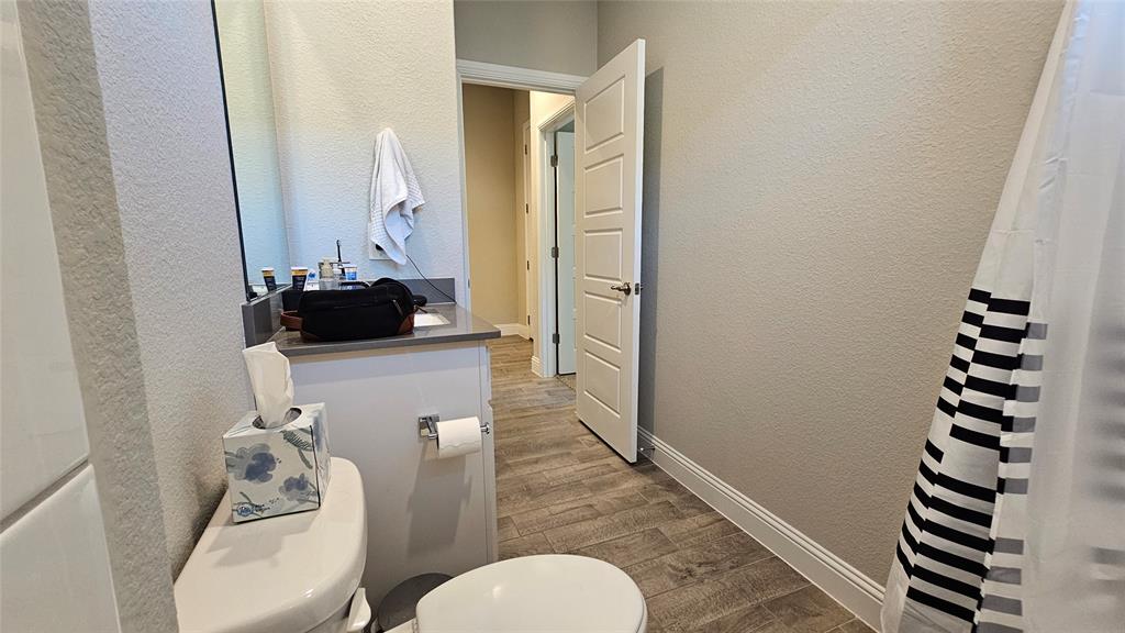 1405 Razorbill Road Denton, TX 76205 - Photo 40 of 40 a bathroom with a toilet a sink and mirror