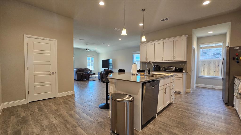 1405 Razorbill Road Denton, TX 76205 - Photo 8 of 40 a kitchen with stainless steel appliances granite countertop a refrigerator stove top oven and sink