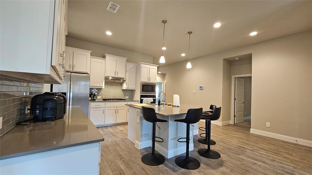 1405 Razorbill Road Denton, TX 76205 - Photo 9 of 40 a kitchen with a sink cabinets and wooden floor