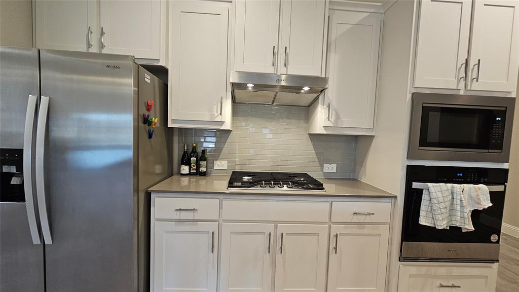 1405 Razorbill Road Denton, TX 76205 - Photo 10 of 40 a kitchen with stainless steel appliances granite countertop a refrigerator sink and stove