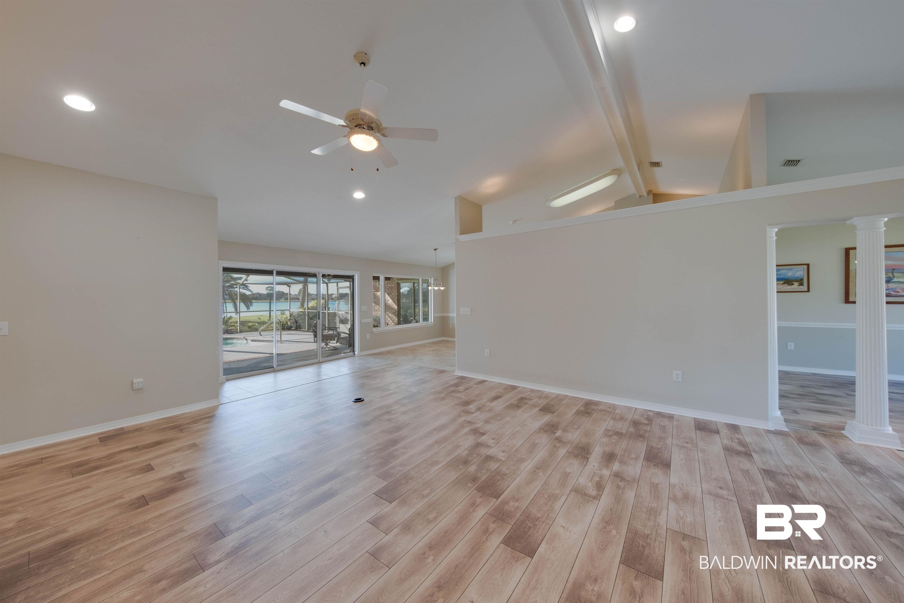 9462 Lakeview Drive Foley, AL 36535 - Photo 11 of 50 Unfurnished living room featuring vaulted ceiling with beams, light hardwood / wood-style flooring, decorative columns, and ceiling fan