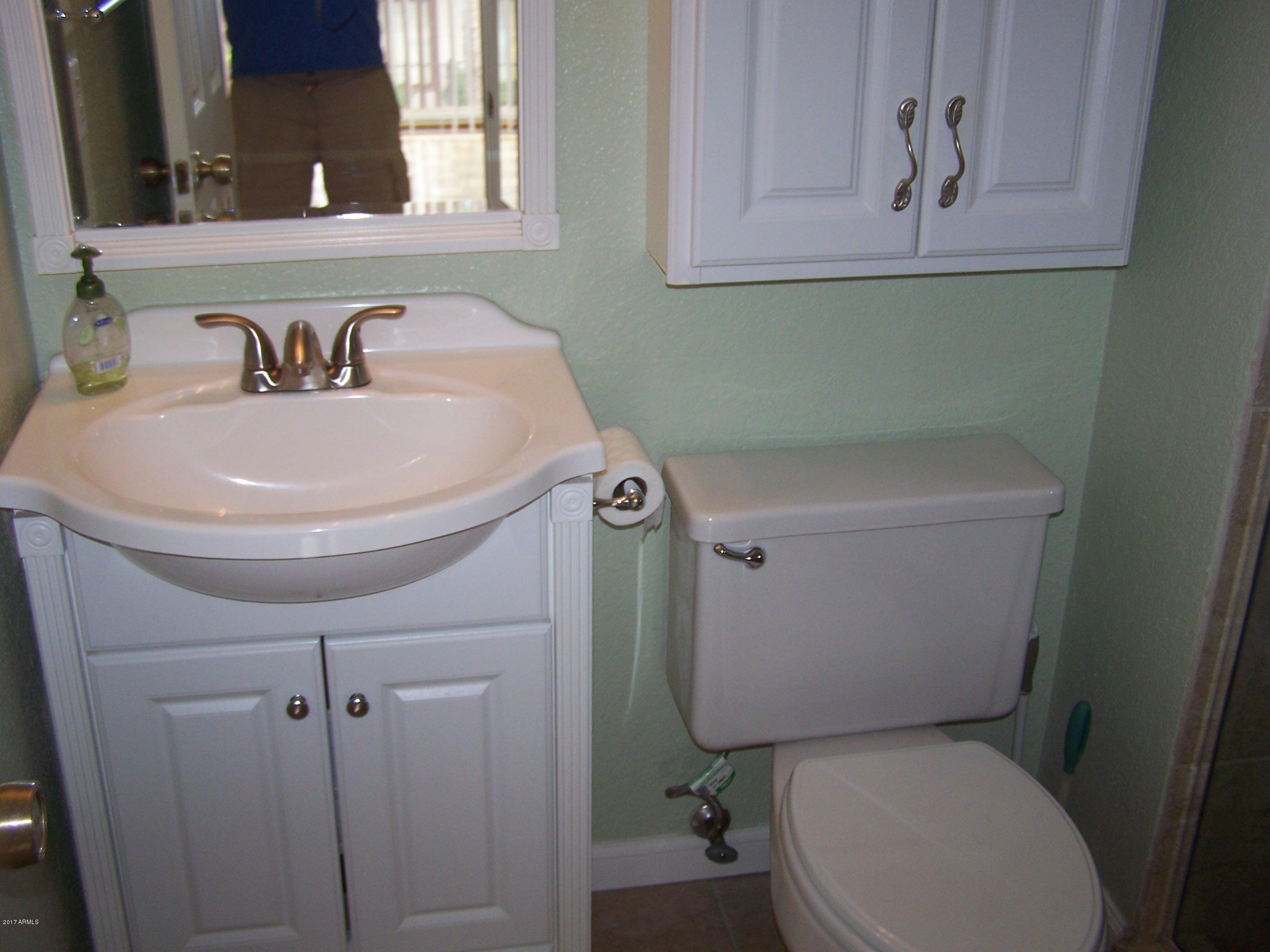 1402 East Osborn Road, Unit 16 Phoenix, AZ 85014 - Photo 5 of 15 a bathroom with a sink a toilet and a mirror