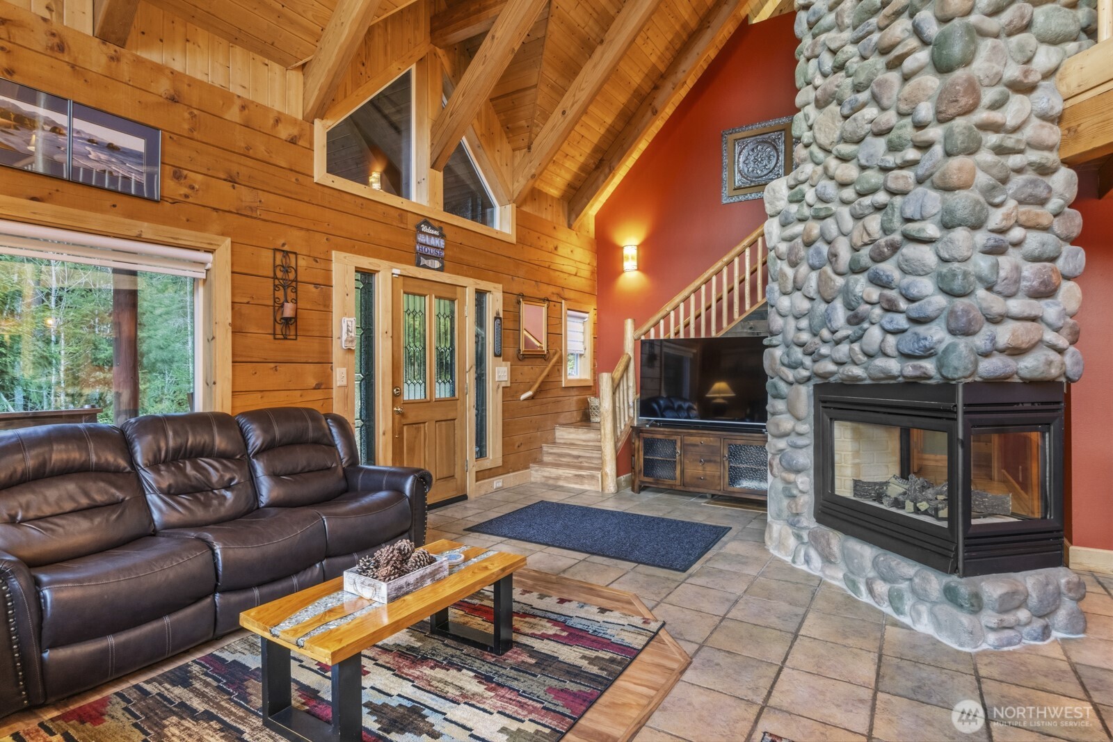 6323 North Lake Cushman Road Hoodsport, WA 98548 - Photo 13 of 40 a living room with furniture a flat screen tv and a fireplace