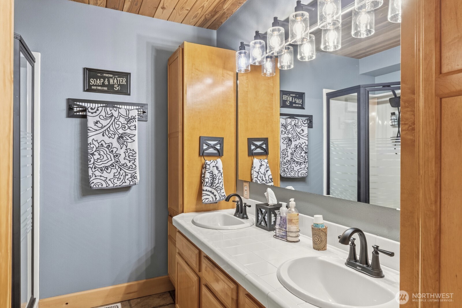 6323 North Lake Cushman Road Hoodsport, WA 98548 - Photo 24 of 40 a bathroom with a sink a mirror a vanity and a shower