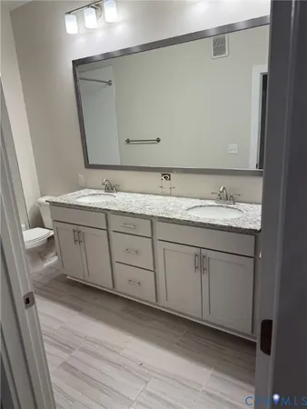 a bathroom with a double vanity sink and mirror