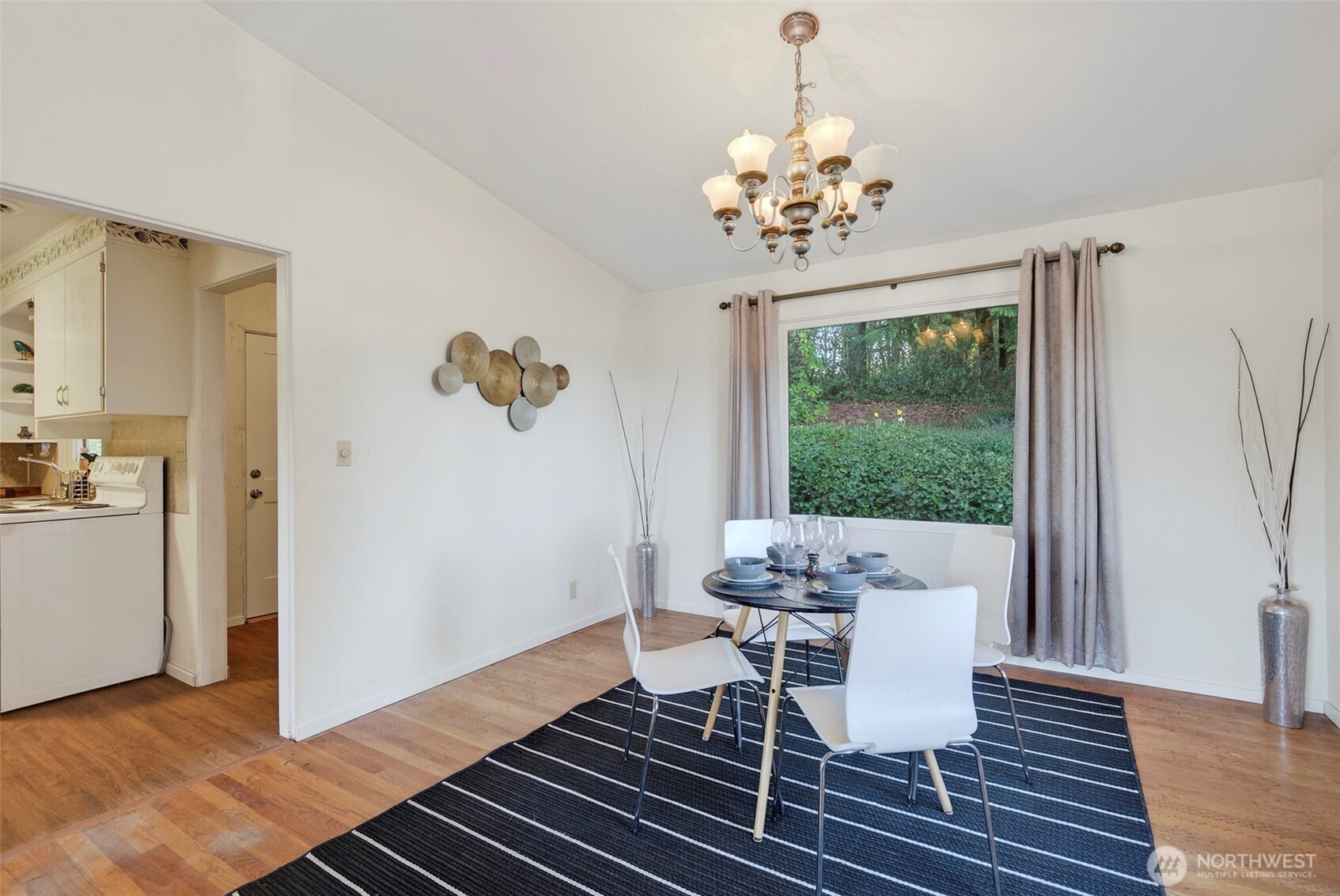 312 Southeast 2nd Street Winlock, WA 98596 - Photo 11 of 40 a dining room with wooden floor a chandelier a glass table and chairs