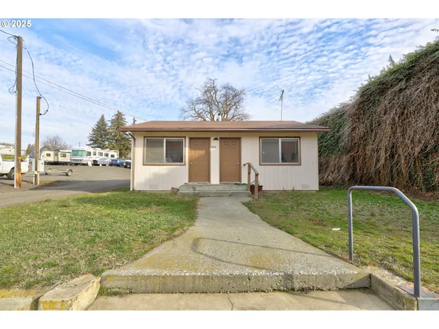 a backyard of a house with a garden and barbeque oven