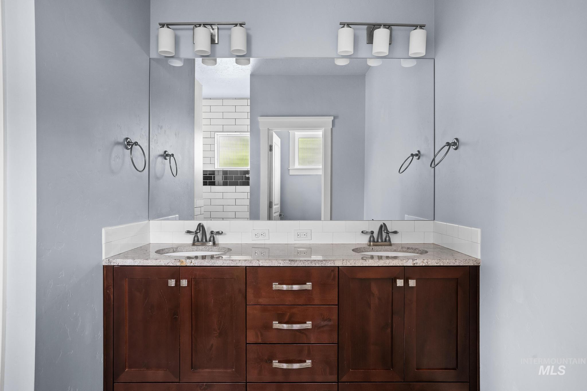 2681 East Rhyolite Court Nampa, ID 83686 - Photo 26 of 48 Dual vanity with dark wood cabinetry and stone countertops