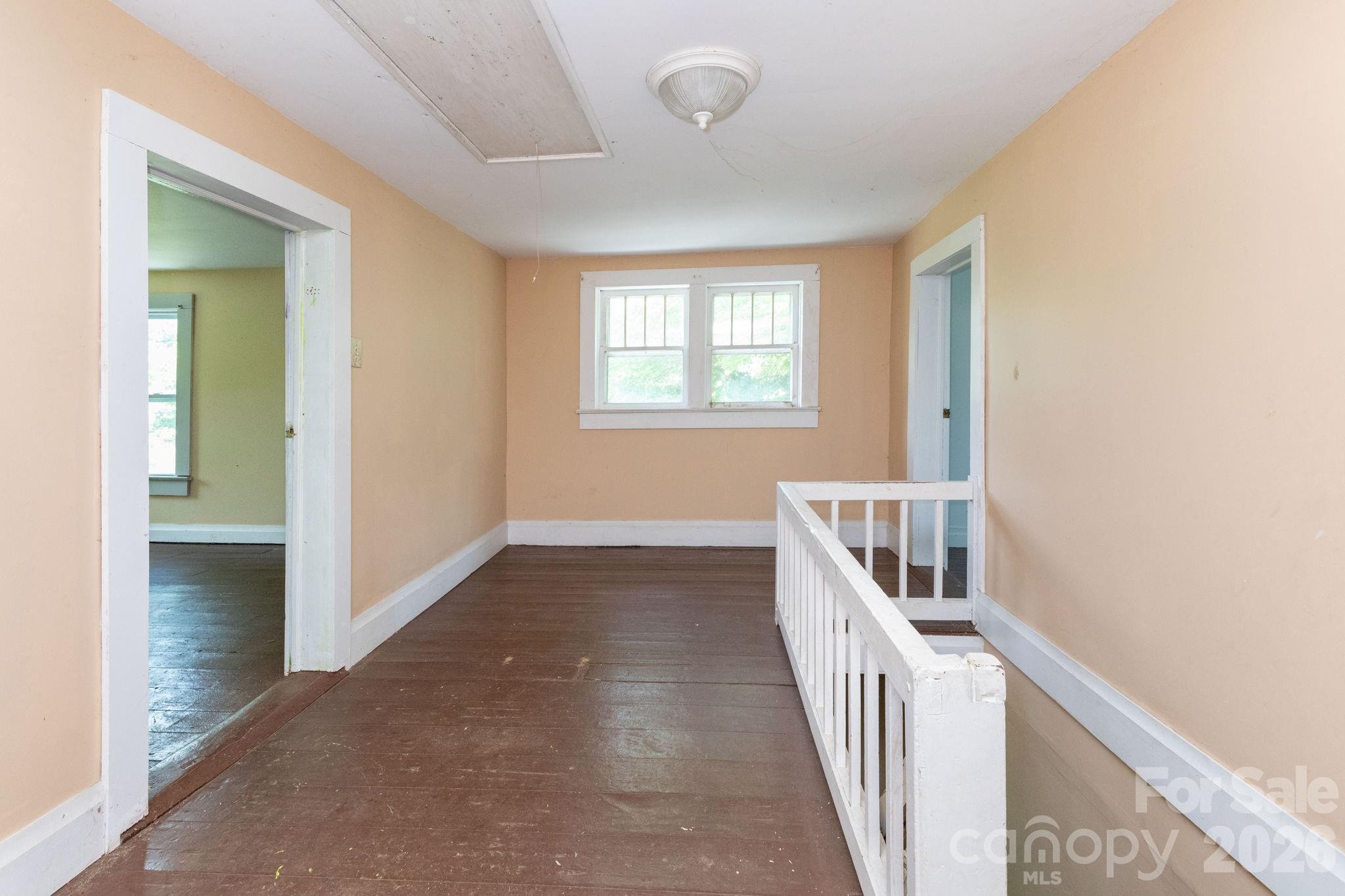 4085 Jacks Creek Road Burnsville, NC 28714 - Photo 17 of 24 a view of a hallway with wooden floor and stairs