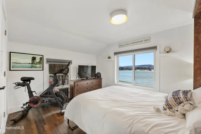 a bedroom with a bed and a flat tv screen on the dresser