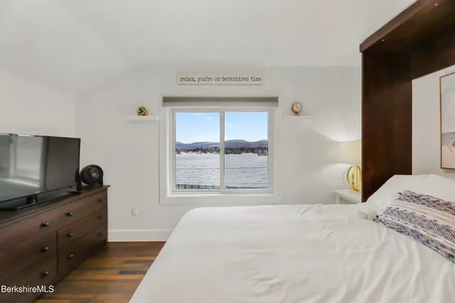 a bedroom with a bed and a flat tv screen on dresser