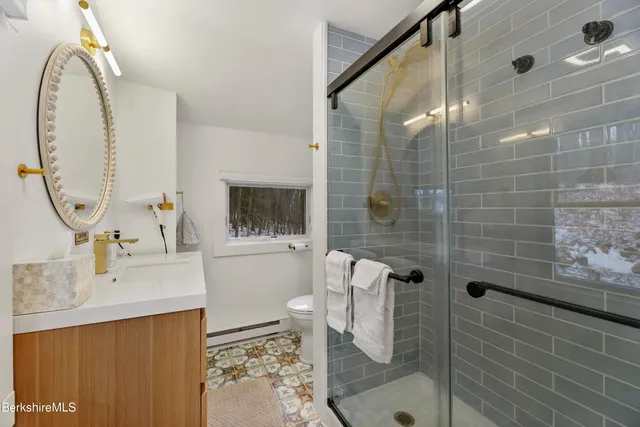 a bathroom with a sink a toilet and shower