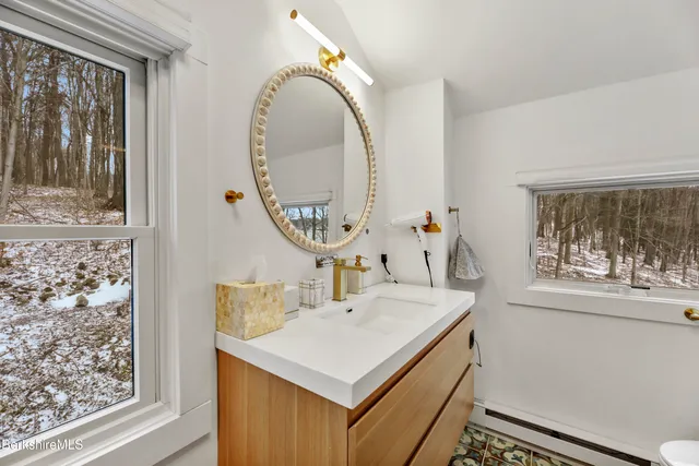 a bathroom with a sink a mirror and a window