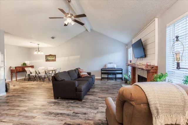 a living room with furniture a fireplace and a flat screen tv