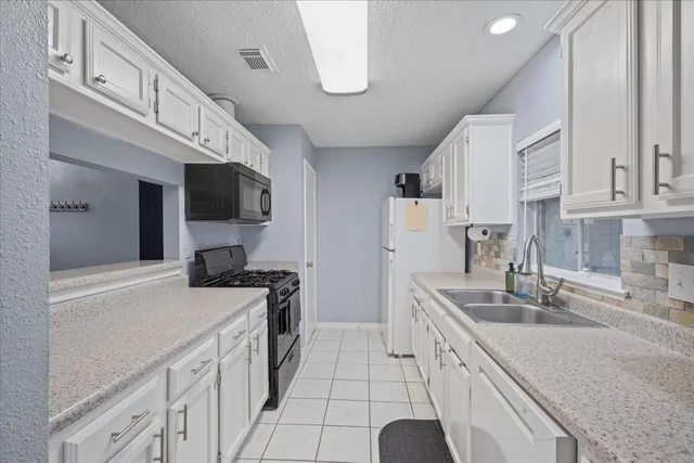 a kitchen with a sink a stove and cabinets