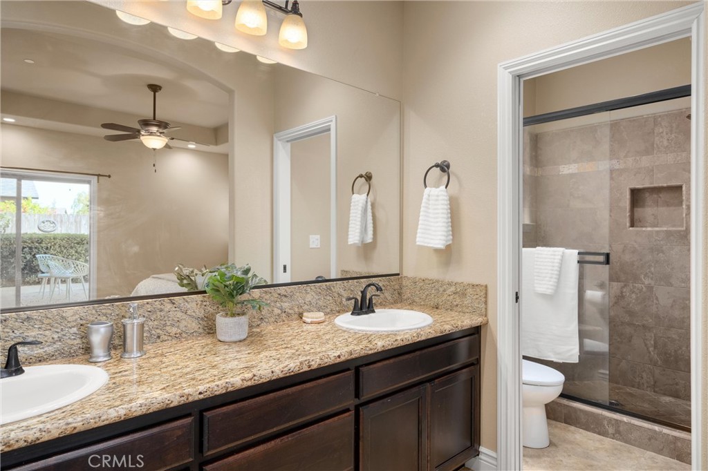 2775 Levi Lane Chico, CA 95973 - Photo 25 of 34 a bathroom with a granite countertop sink a toilet and a mirror