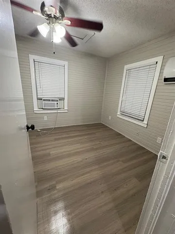a view of an empty room with a window and a chandelier fan