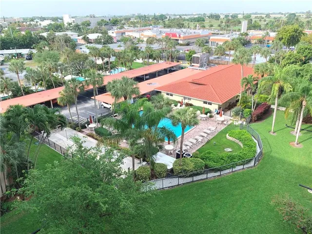 an aerial view of residential houses with outdoor space and trees
