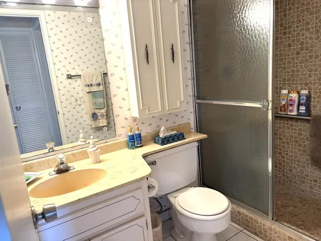 a bathroom with a granite countertop toilet a sink and a mirror