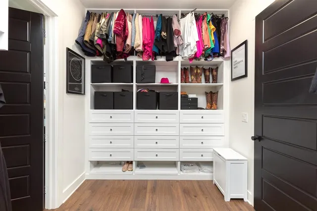 a view of walk in closet with clothes and shoes