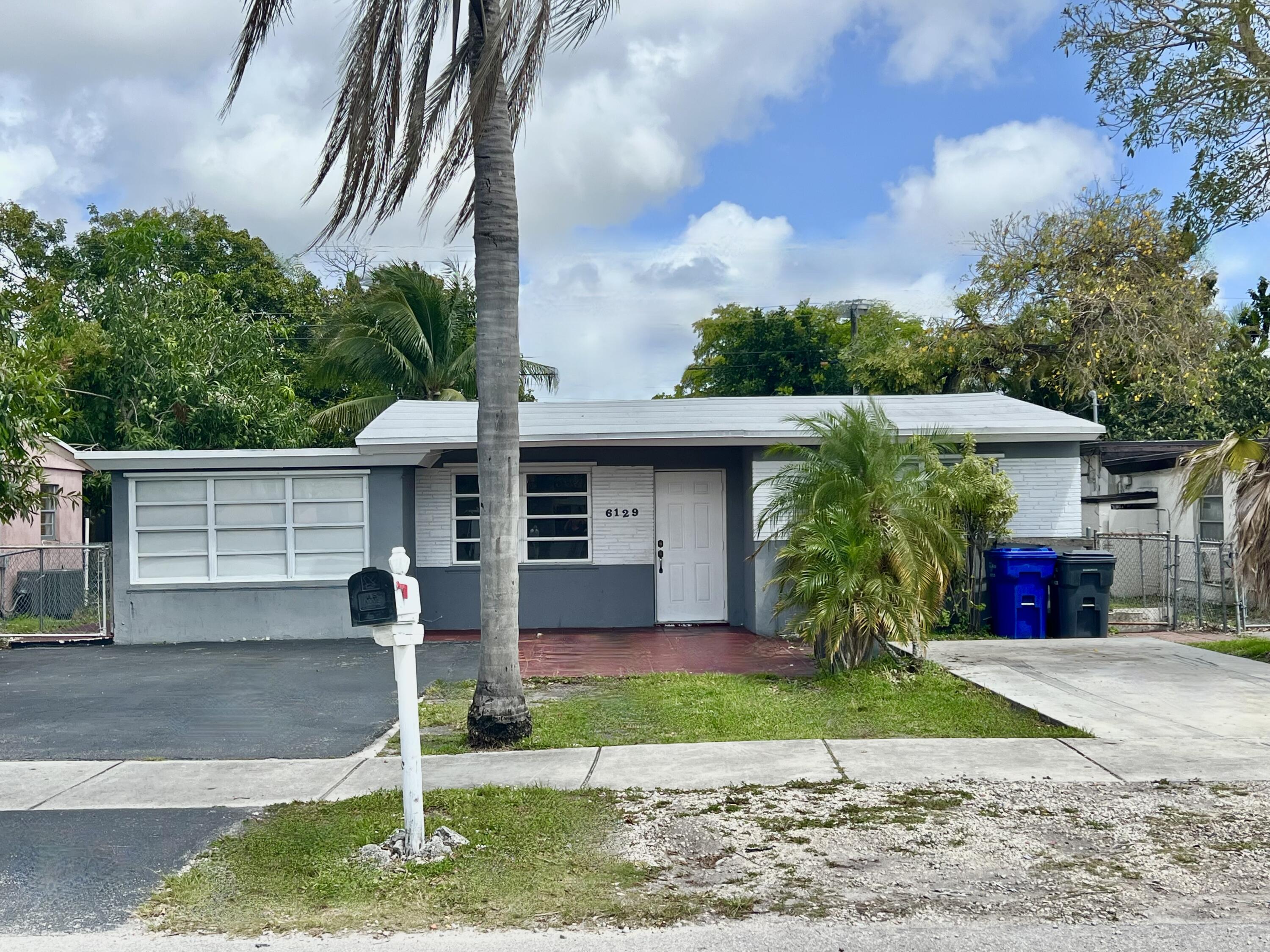 6129 Funston Street Hollywood, FL 33023 - Photo 1 of 18 a front view of house with yard and green space