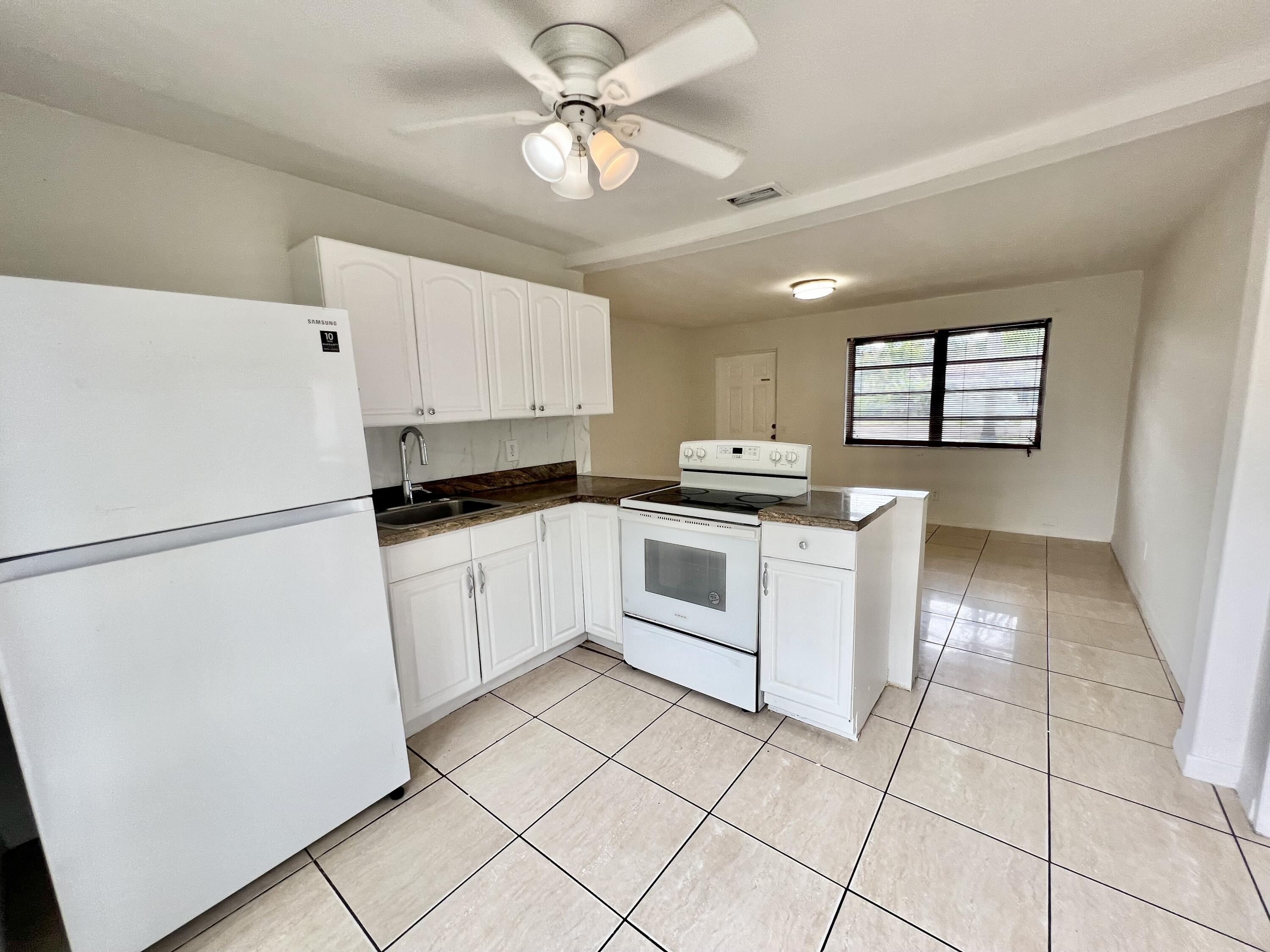 6129 Funston Street Hollywood, FL 33023 - Photo 6 of 18 a kitchen with white cabinets and white appliances