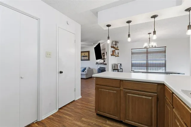 a kitchen with stainless steel appliances granite countertop a sink and a wooden floor