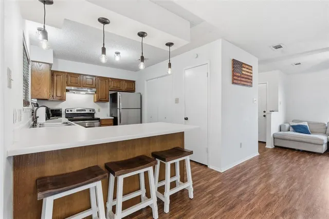 a kitchen with granite countertop a stove a sink and wooden floor