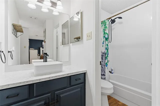 a bathroom with a sink a toilet a mirror and shower