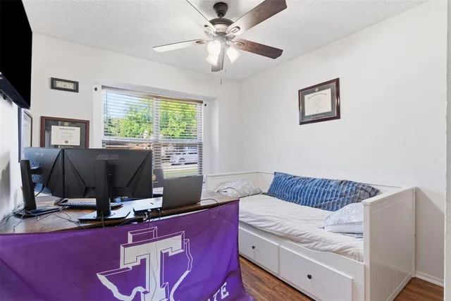 a living room with a bed furniture flat screen tv and a large window