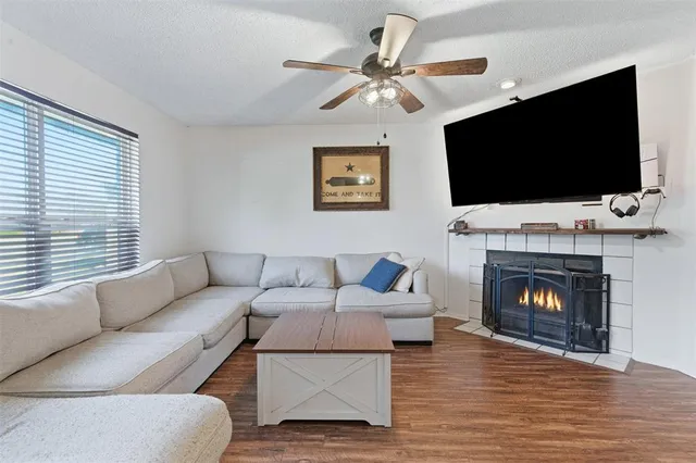 a living room with furniture a flat screen tv and a fireplace