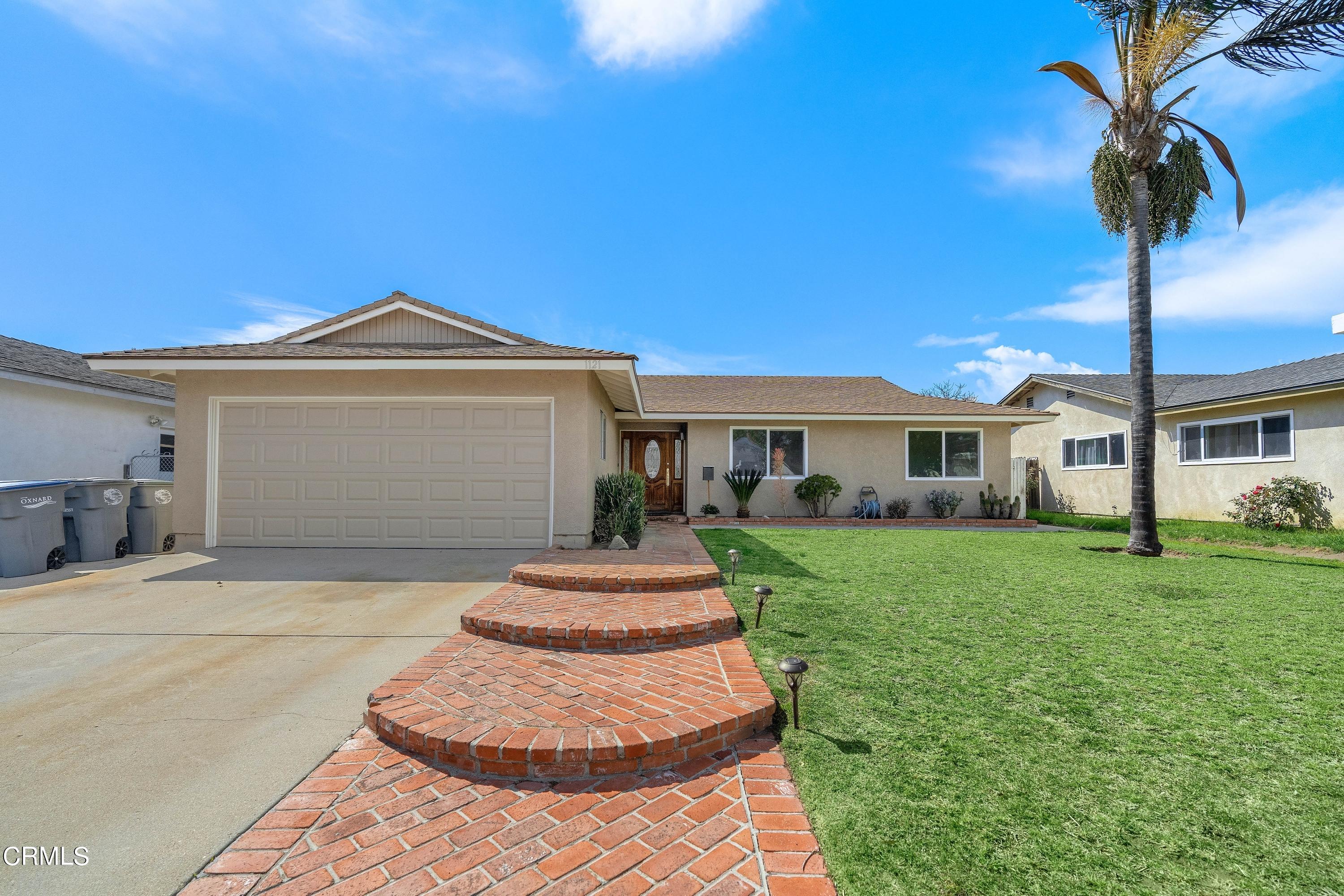 1121 Rachel Drive Oxnard, CA 93030 - Photo 2 of 21 a front view of a house with a yard and garage