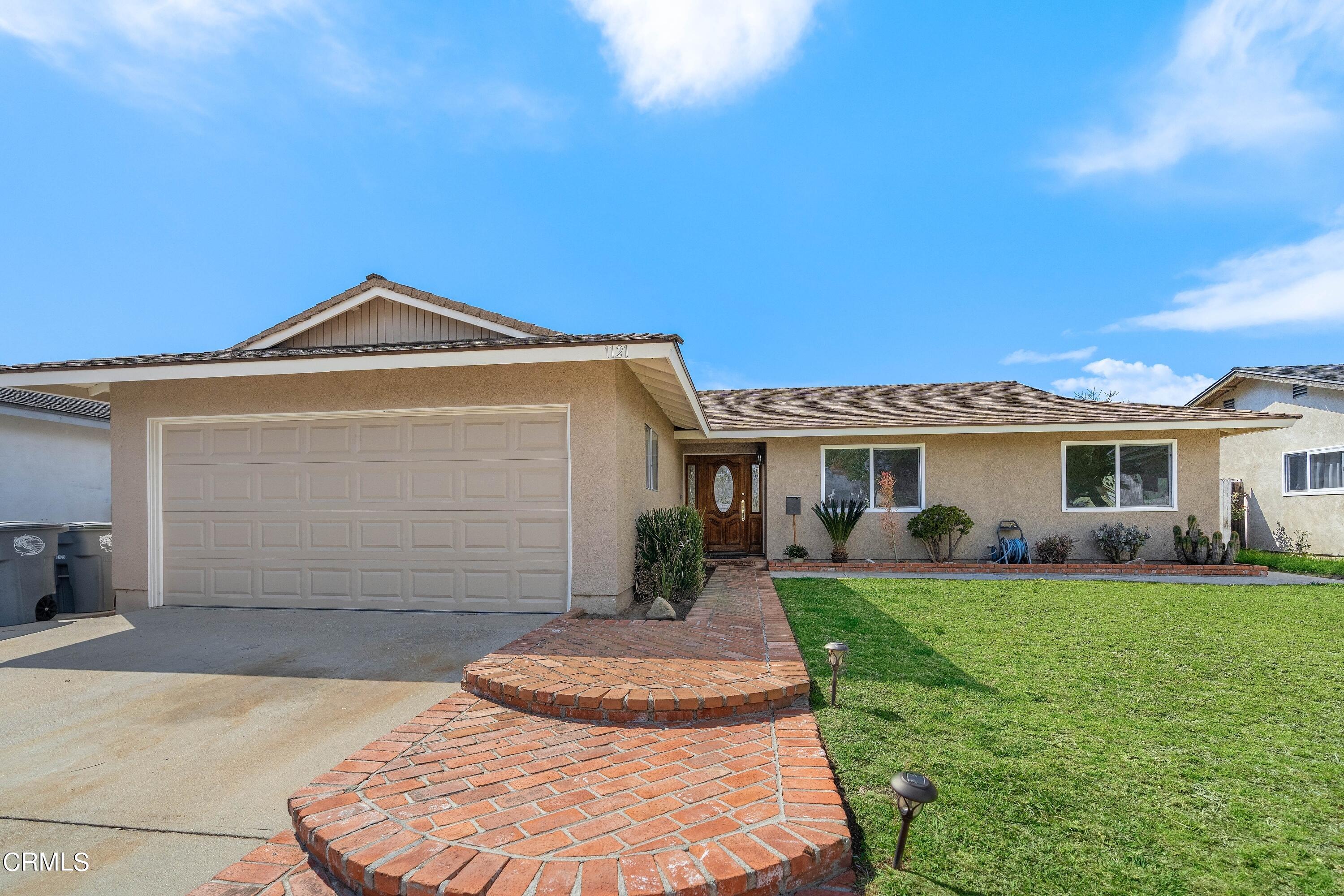 1121 Rachel Drive Oxnard, CA 93030 - Photo 3 of 21 a front view of a house with a yard and trees