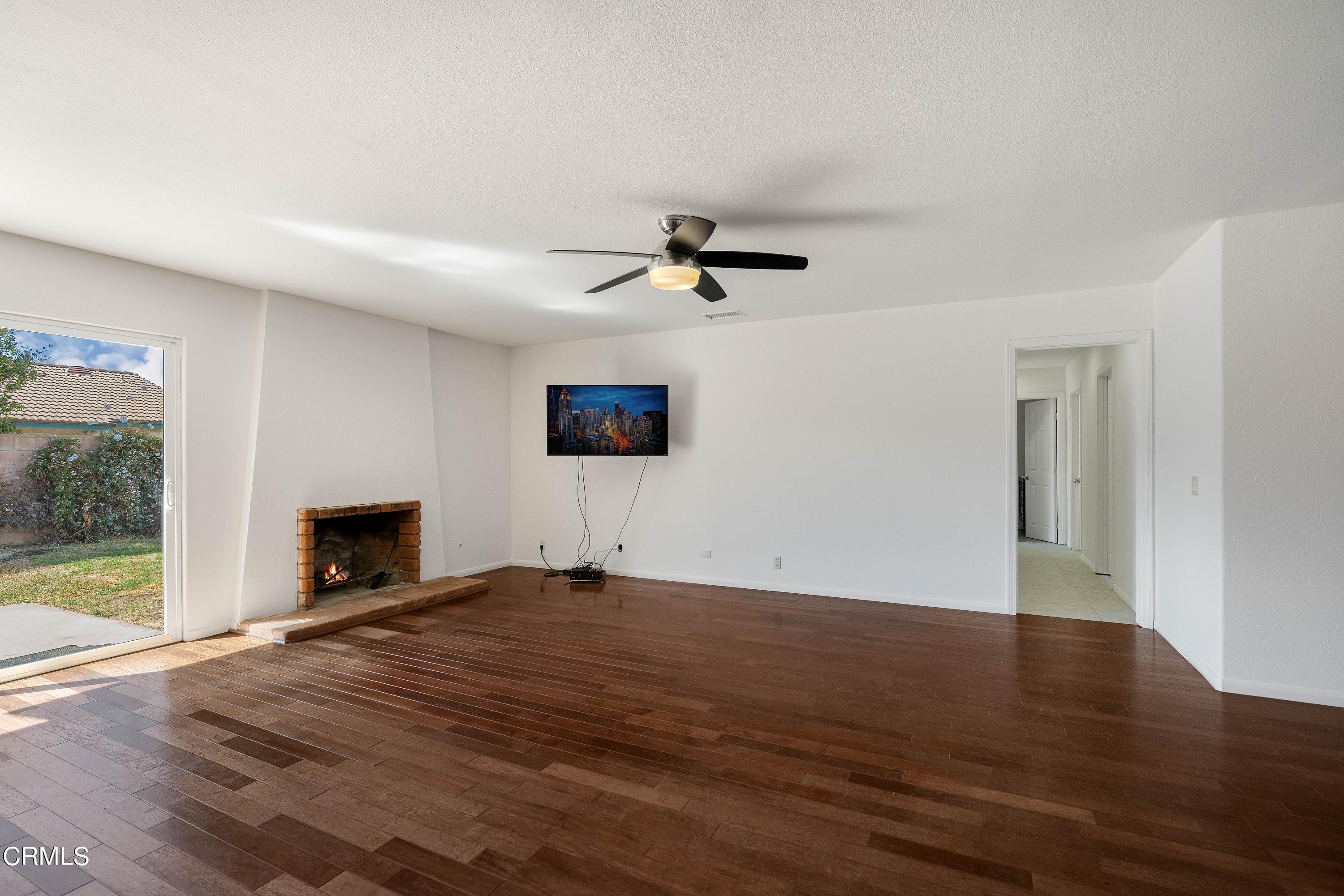 1121 Rachel Drive Oxnard, CA 93030 - Photo 10 of 21 a view of an empty room with wooden floor and a fireplace