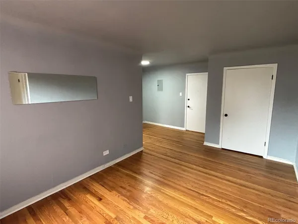 a view of an empty room with wooden floor