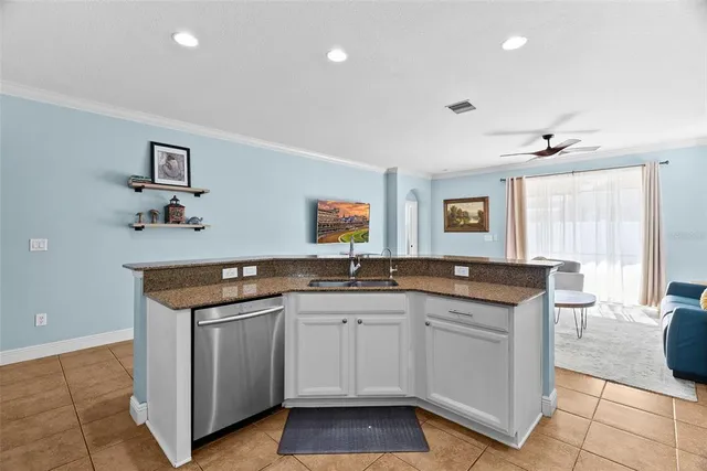 a kitchen with sink a window and cabinets