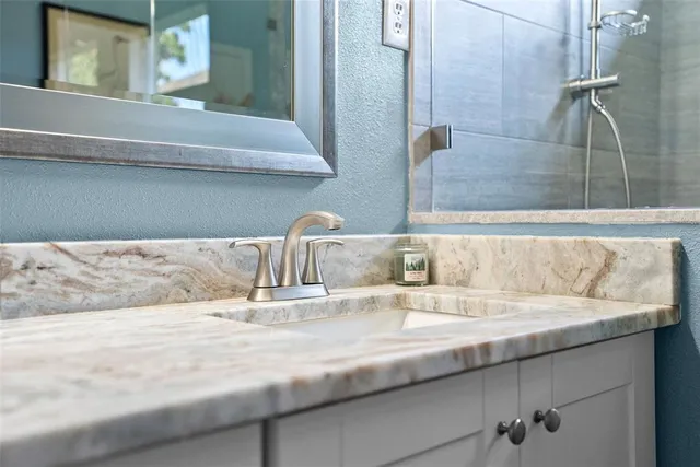 a bathroom with a granite countertop sink toilet a large mirror a shower and a bathtub