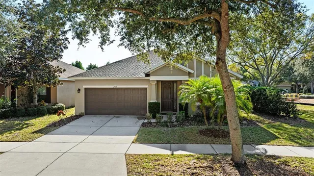 an aerial view of residential houses with city and green space