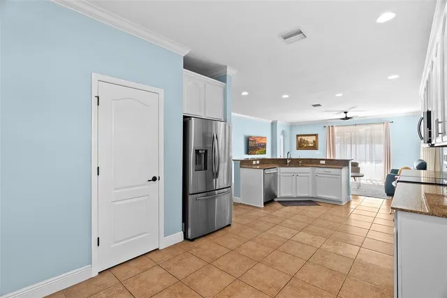 a kitchen with stainless steel appliances granite countertop a refrigerator sink and white cabinets