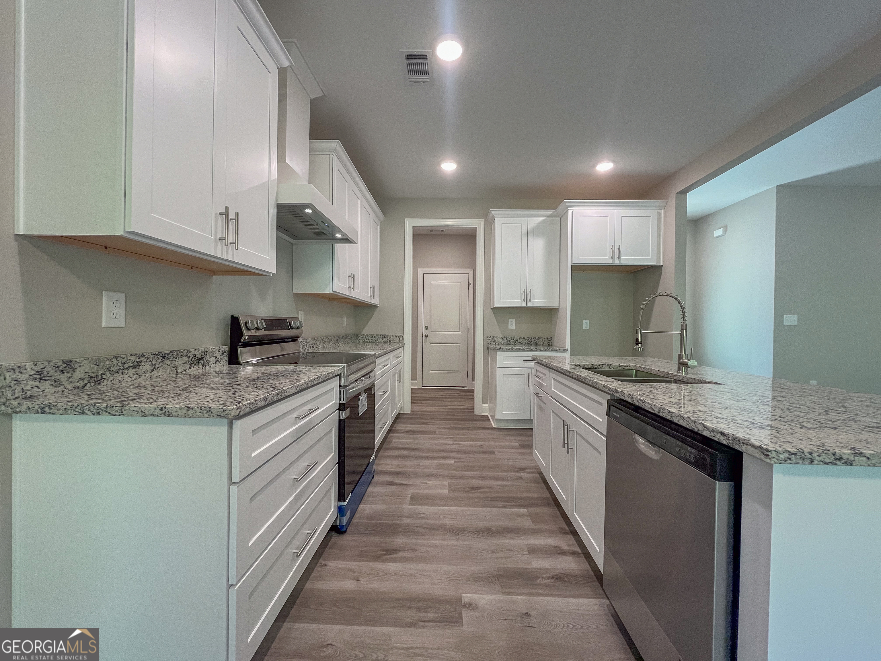 711 Flanders Lane Dublin, GA 31021 - Photo 10 of 49 a kitchen with granite countertop stainless steel appliances and white cabinets