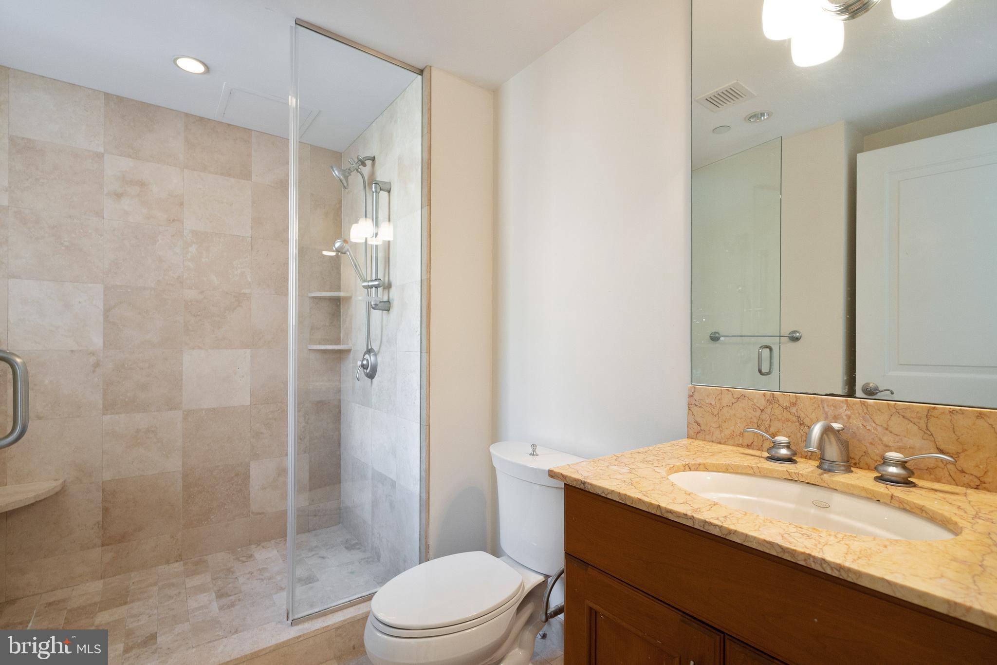 1701 Locust Street, Unit 1417 Philadelphia, PA 19103 - Photo 13 of 29 a bathroom with a granite countertop sink a toilet and shower