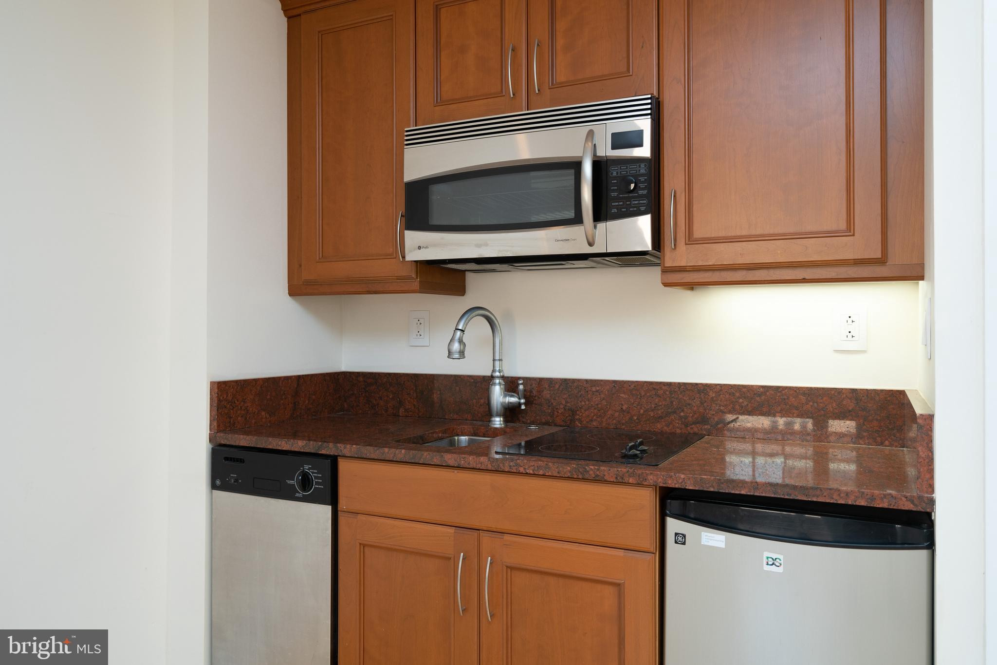 1701 Locust Street, Unit 1417 Philadelphia, PA 19103 - Photo 4 of 29 a kitchen with granite countertop white cabinets stainless steel appliances and a sink