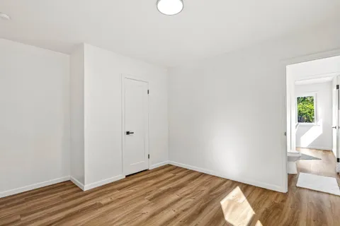 a view of a room with wooden floor and white walls