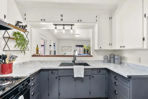 a kitchen with kitchen island granite countertop a sink stainless steel appliances and cabinets