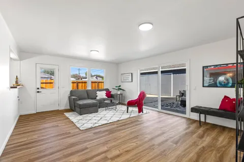 a living room with furniture and a wooden floor