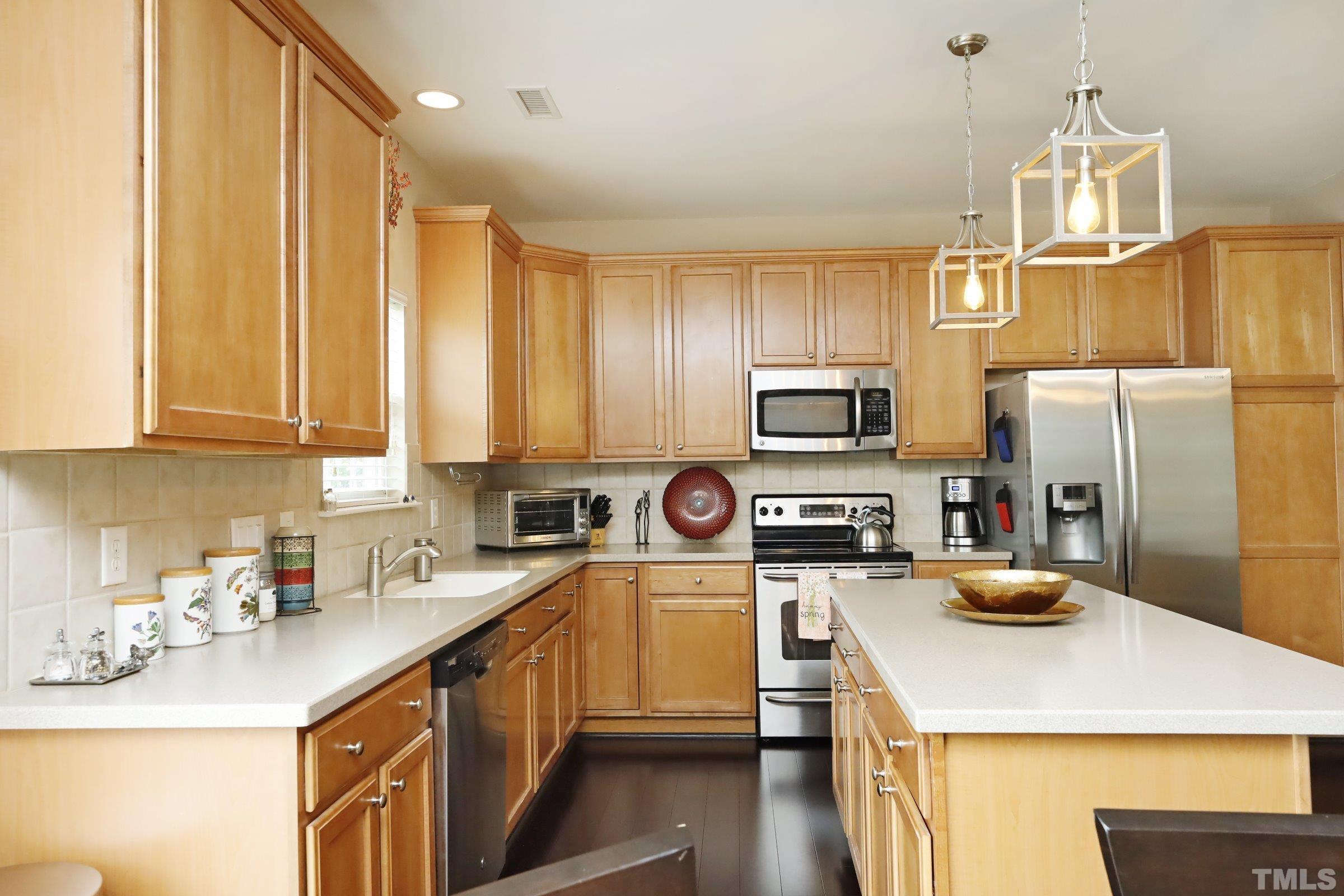 5325 Glass Ridge Road Raleigh, NC 27616 - Photo 15 of 42 a kitchen with a sink a counter space cabinets and stainless steel appliances